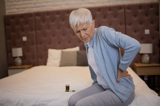 istock Senior woman with back pain sitting on couch 1481787449