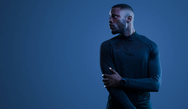istock Unconfident black sportsman standing on blue background 1481789278
