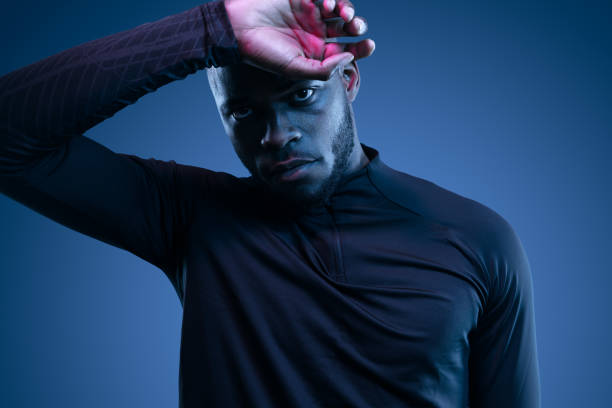 istock Tired black sportsman wiping sweat from forehead in studio 1481789283
