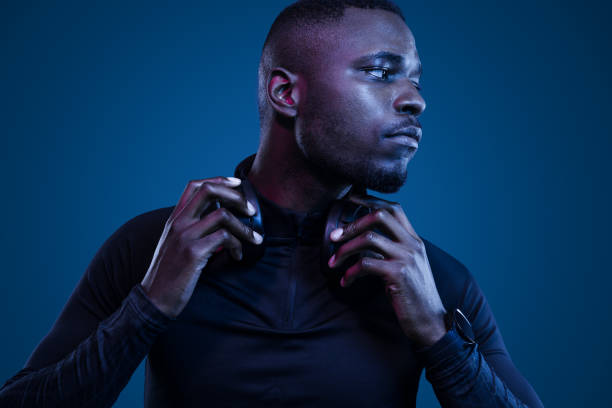 istock Athletic black man adjusting headphones and looking away 1481789299