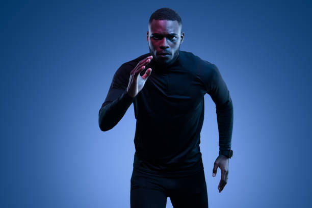 istock Fit strong young black guy running in blue studio 1481789312