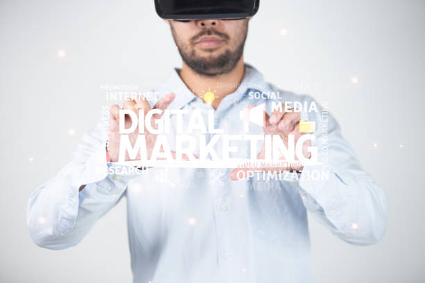 istock Man wearing virtual reality goggles with digital marketing words above his head. 1481789664
