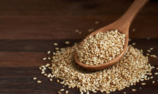 istock sesame seed in wood spoon on wooden table background. 1481794837
