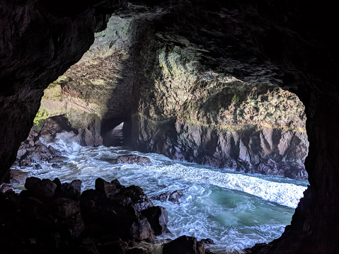 This is a landscape photograph of the interior of a cave opening up to the Pacific Ocean along the Oregon coast in the Pacific northwest USA.