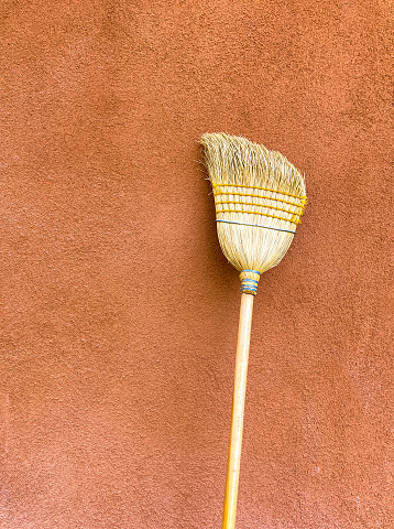 Adobe Wall Background with Old Yellow Broom