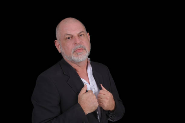 istock Handsome middle-aged man in a suit posing against black background. confident business man 1481812805