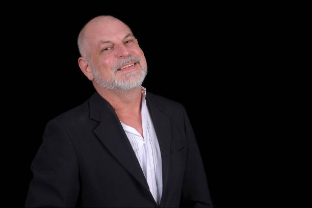 istock Handsome middle-aged man in a suit posing against black background. confident business man 1481812806
