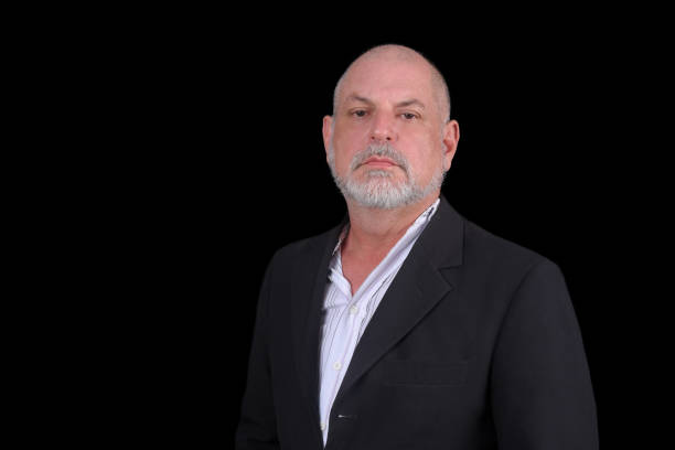 istock Handsome middle-aged man in a suit posing against black background. confident business man 1481812807