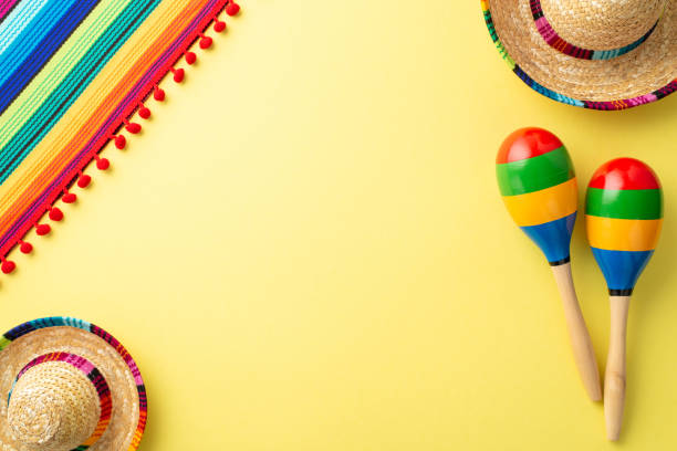istock A top view of poncho, and maracas mexican hat on light yellow background with empty space 1481821101