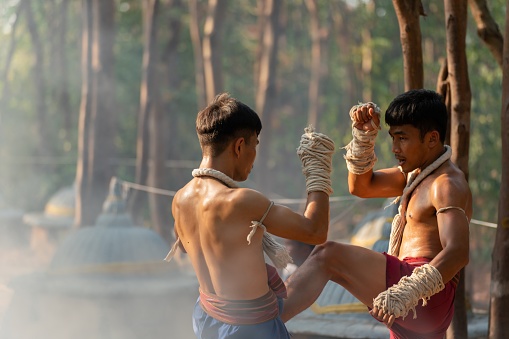 Moment of a two male muay thai practitioner demonstrating muaythai techniques and skill during sunset moments