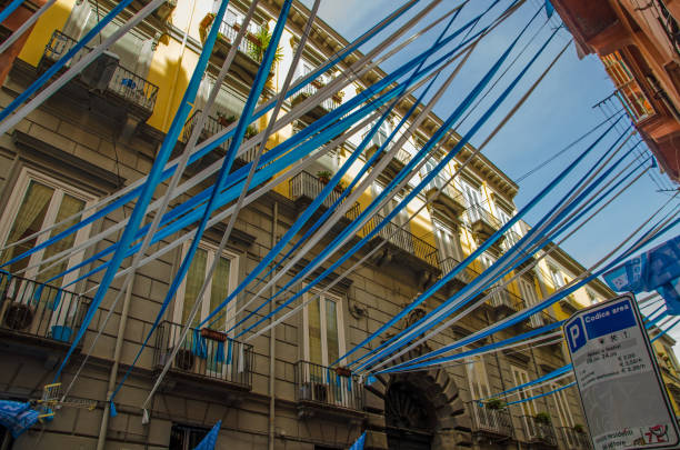 View looking up through blue and white bunting, flags and streamers in the historic city centre of Naples as residents celebrate the success of S.S.C. Napoli football club.