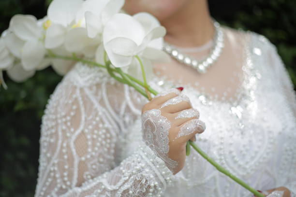 the bride's hands are decorated with white henna which is very beautiful