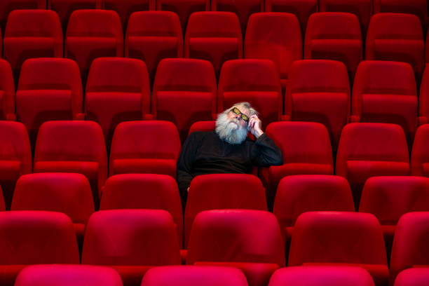 istock Concept boredom:One man  sits in Empty cinema or theatre, sleeping 1481831042