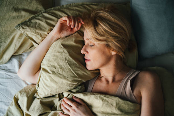 vista superior de la mujer durmiendo en la cama - sleep fotografías e imágenes de stock