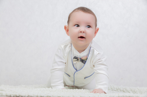 A smile on a child's face. Portrait of a six month old boy in elegant clothes. Generation Alpha. The concept of motherhood and fatherhood.