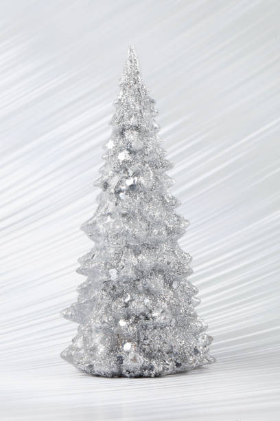 istock Christmas composition. Silver Christmas tree on a silver background. Happy Holidays. Minimal new year concept. 1481835239