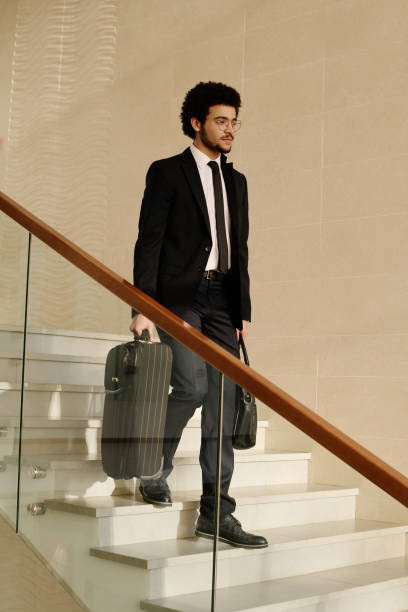 istock Man with suitcases moving down the stairs 1481837707