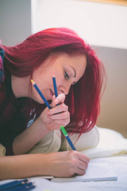 istock Woman drawing pictures while lying on bed 1481839149