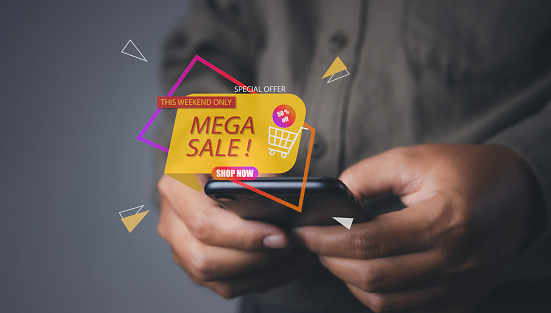 Shopping online by mobile smart phone. Young man using mobile phone shopping online with mega sale discount promotion, E-commerce business online. copy space.