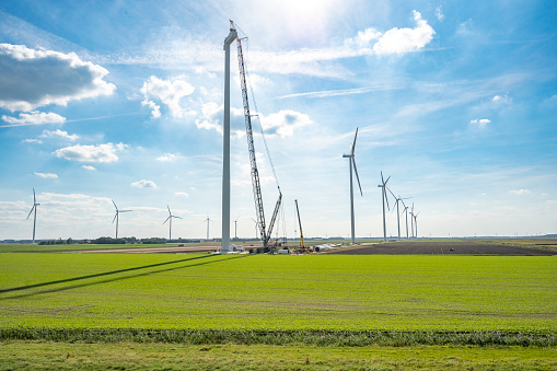 Wind turbine construction with huge cranes at a new wind park in Flevoland, Netherlands.