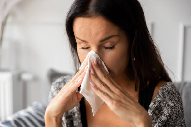 istock Sick woman blowing her nose 1481843422