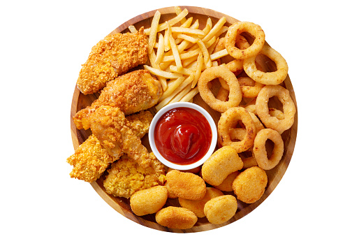 plate of fast food meals : onion rings, french fries, chicken nuggets and fried chicken isolated on white background, top view