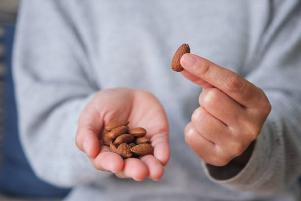 istock Closeup image of hands holding and picking up an almonds 1481843930