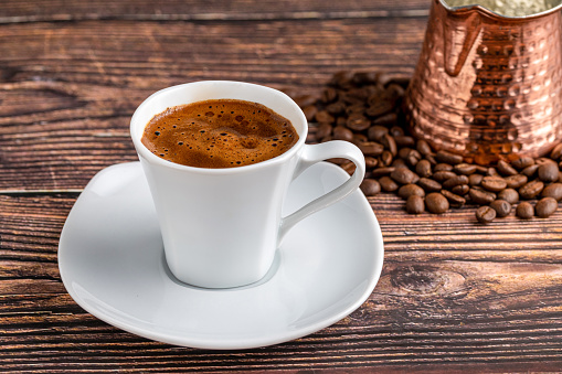 Turkish coffee in modern coffee cup on wooden table