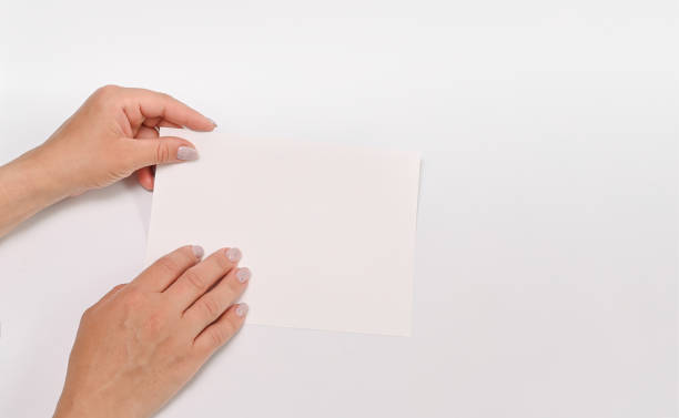 istock a white sheet of paper in your hands for your text. 1481847405