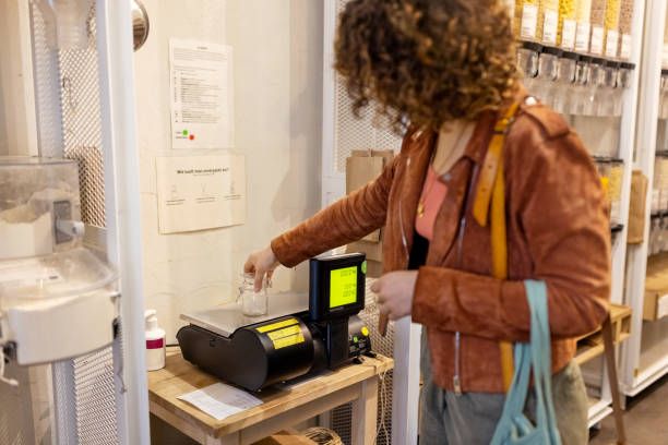 istock Woman customer weighing an empty container at package free grocery store 1481847498