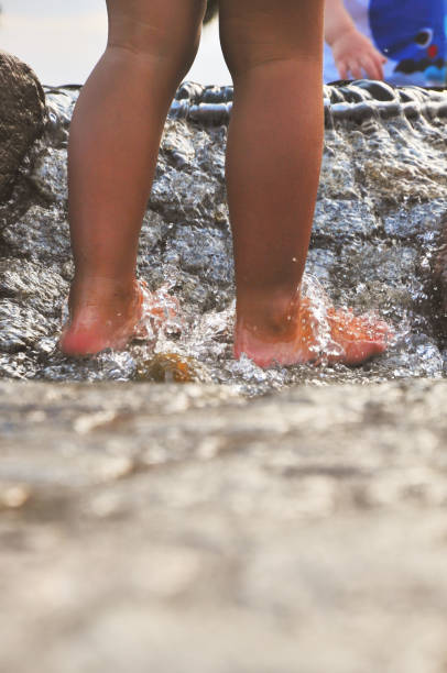 Close-up of young child playing in water during summer