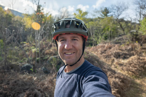 Close up of man with bike helmet in the middle of beautiful nature, early autumn morning.Concept of active and healthy lifestyle.