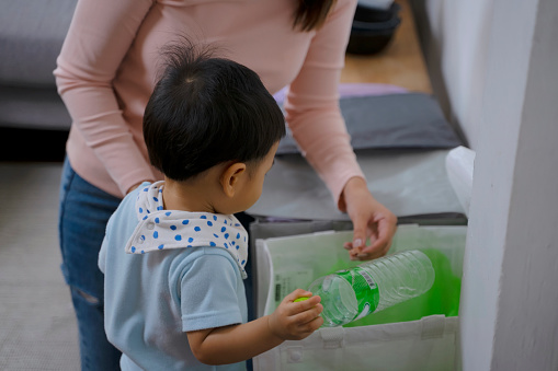 Woman teach son to garbage. Waste and environment concept.