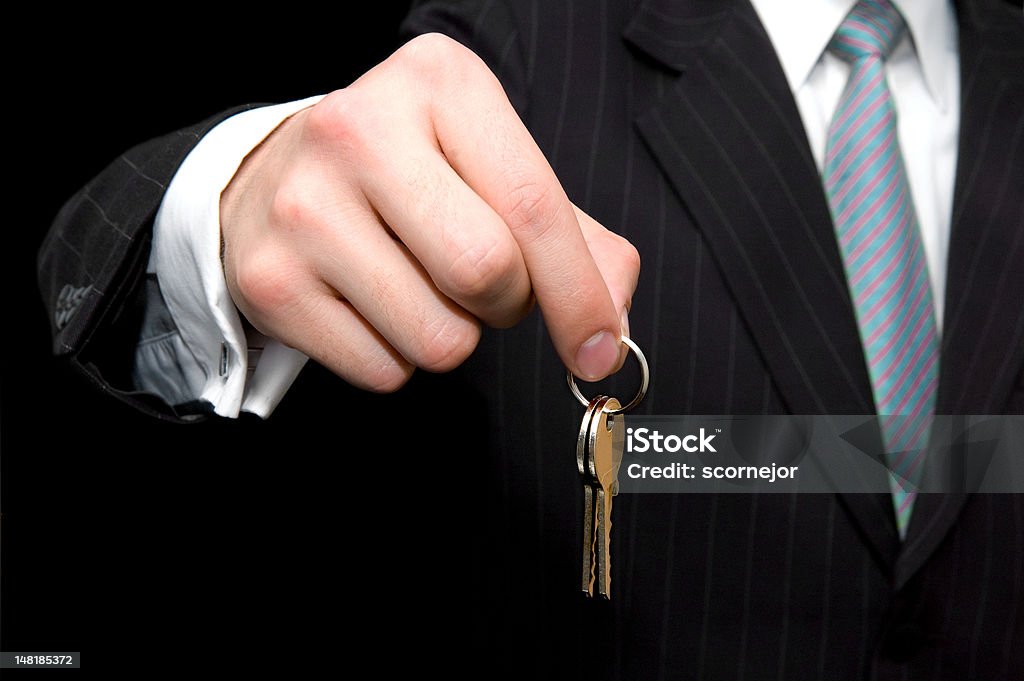Man holding the key of new house or business Businessman - real estate concept: man holding the key of new house or business Apartment Stock Photo