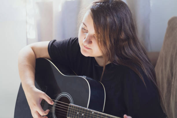 istock Young girl plays the guitar romantically 1481854262