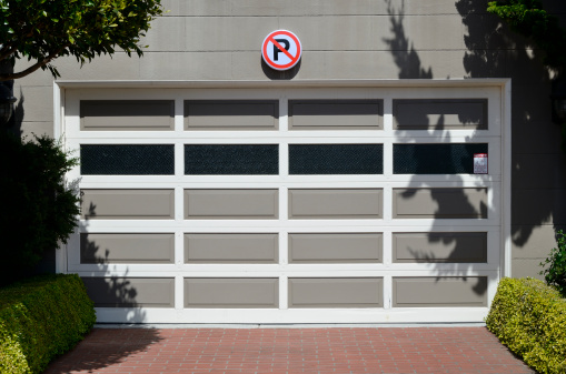 Access to a garage with a no parking sign displayed above the door