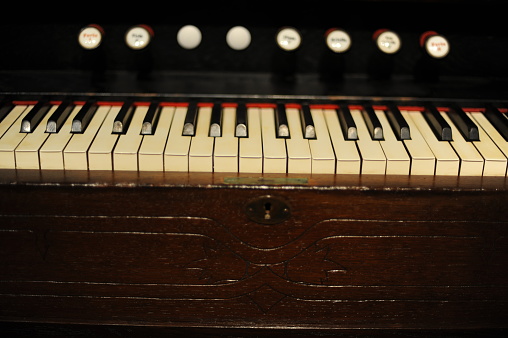 Piano keys or keyboard of old, historic clavichord or harpsichord musical instrument. Close-up photo with selective focus and shallow depth of field