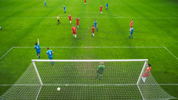 partido del campeonato del estadio de fútbol: el jugador de fútbol recibe un pase exitoso, patea la pelota y marca un gol increíble, el portero salta pero no logra salvar los goles. tiro de ángulo alto en el torneo - pass the ball fotografías e imágenes de stock