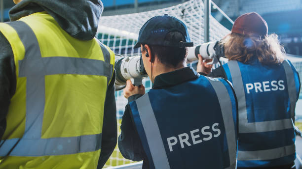 전문 언론 담당관, 카메라 줌 렌즈를 가진 스포츠 사진 작가가 경기장에서 축구 챔피언십 경기를 촬영합니다. 인터내셔널 컵, 월드 토너먼트 이벤트. 사진, 저널리즘, 미디어 - 스포츠 사진작가 뉴스 사진 이미지