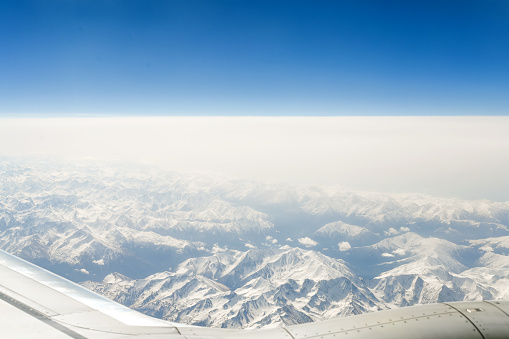 view of the snow-capped mountains from the airplane window