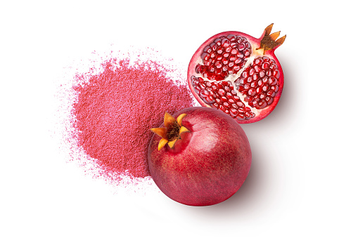 Pomegranate powder with fresh fruit isolated on white background. Top view, flat lay.