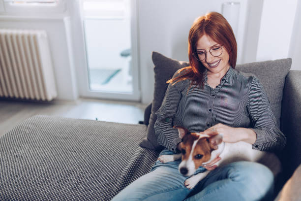 istock Natural ginger in her living room with her small dog 1481865968