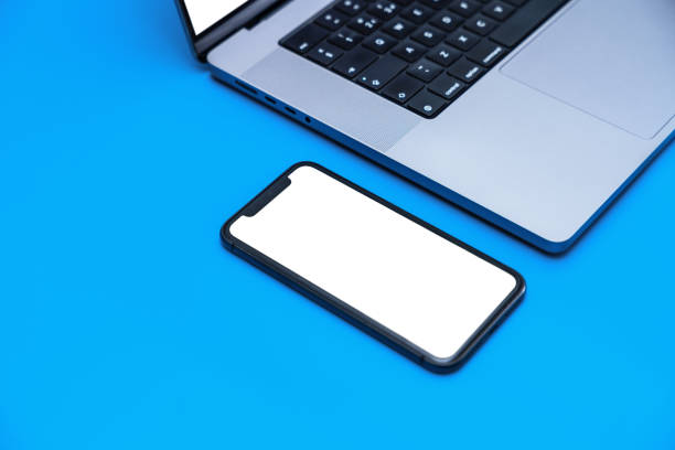 istock Smartphone with blank white screen laying at the laptop. App screen mockup 1481866065