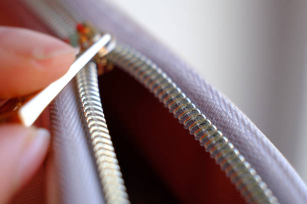 Selective focus, yellow metal zipper of a makeup bag or small purse macro pattern background.