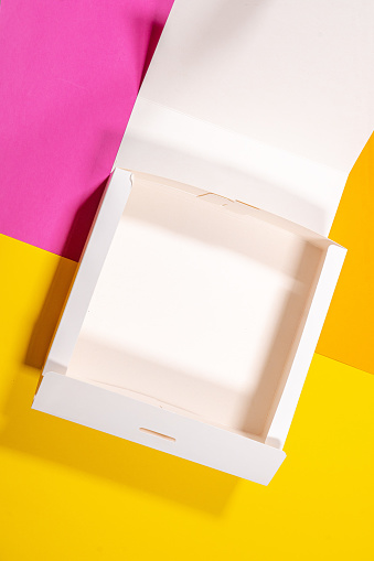 Simple white cardboard box on color background, top view