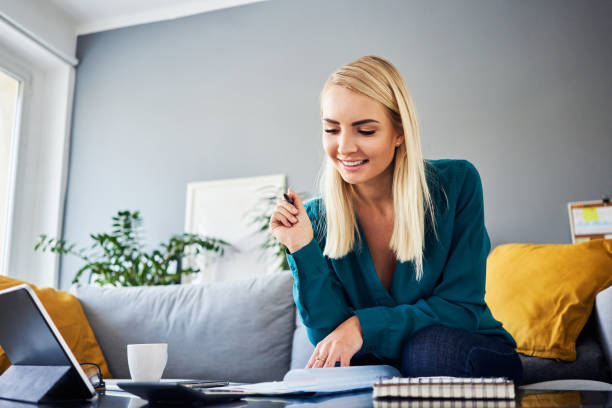 istock Smiling young woman working at home analysing financial documents 1481875340