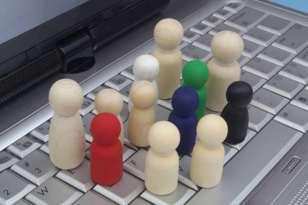 istock Different wooden figures of people on laptop computer keyboard. 1481876441