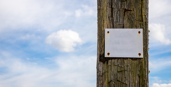 old wooden sign with sky in background