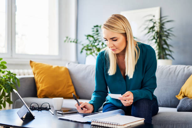 istock Woman while calculating home finances sitting on sofa at home 1481877477