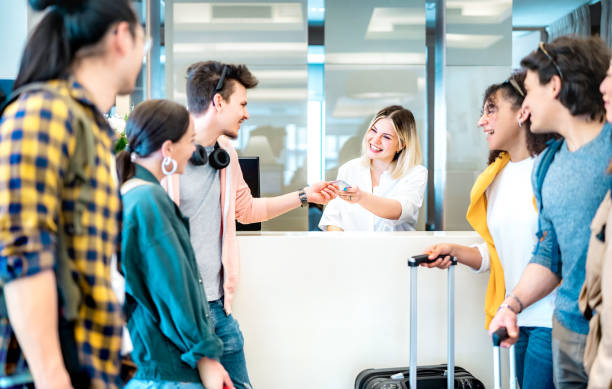 Young millenial friends having fun time at hotel reception desk on check in time - Travel life style concept with happy people waiting at guesthouse desk on fancy vacation - Bright vivid filter jóvenes amigos del milenio divirtiéndose en la recepción del hotel a la hora del check in - concepto de estilo de vida de viaje con gente feliz esperando en el mostrador de la casa de huéspedes en vacaciones elegantes - filtro vívido brillante